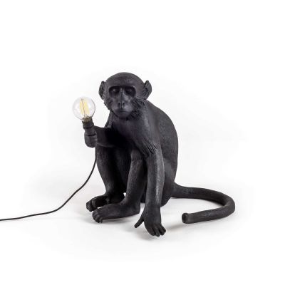 Schwarze Seletti Affenlampe, sitzend, hält eine Glühbirne. Dekorative Tischleuchte für Innen und Außen.